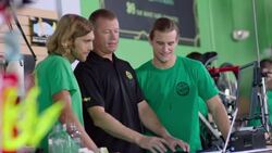 Manager explains system to employees on laptop computer in bike shop Stock Footage