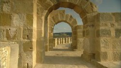 Archways of the Oudna Amphitheater ruins frame mountains in Tunisia. Stock Footage
