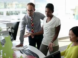 MS R/F three coworkers in discussion at workstation in office/Seattle, Washington, USA Stock Footage