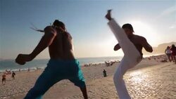 Brazilian capoeira martial artists trade continuous kicks by Copacabana Beach Stock Footage