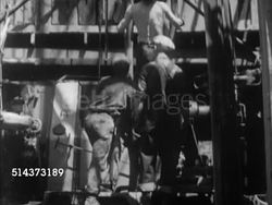 1952: CANADA: OIL INDUSTRY: AERIAL Oil field w/ derrick. TU Men working on tower, LA WS Men working at base, pulling pipe into place, rig center, TU LS Line & blocks above rising drill pipe, 'Derrickhand' throwing rope around pipe, CU Line & block ris Instructional Video