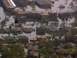 Aerial Chinook helicopter flying sand bags over flooded street / New Orleans, Louisiana Stock Footage