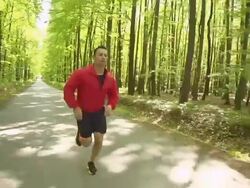 HD STEADY: Young Man Jogging In The Forest Stock Footage