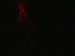 Wide shot of ash exploding from crater and avalanche of lava down side of volcano at night, Philippines, Dec 2009 Stock Footage
