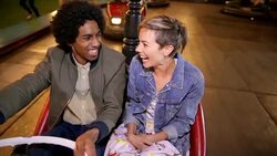 Couple driving bumper car at amusement park Stock Footage