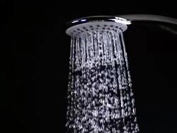 CU SLO MO Shot of shower spraying water out against black background / Calvados, Normandy, France Stock Footage