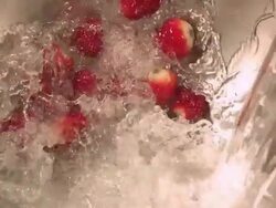 Mineral water pouring onto strawberries in steel bowl. Stock Footage