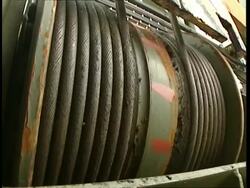 CU Cable drum winding up thick steel cable Stock Footage