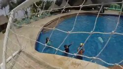 Kids in pool playing basketball throw ball into net at resort. Stock Footage