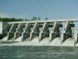 WIde shot of Water spillway behind electricity generating dam Stock Footage