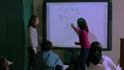 Teacher calls student up to use Smart Board Stock Footage