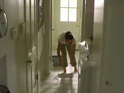 WS, PAN, Woman mopping tile floor in laundry room, Hollywood, California, USA Stock Footage