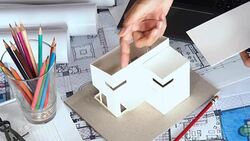 Architect working with house model & blue prints Stock Footage