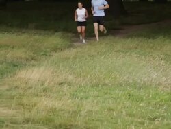 Male and female running trough park Stock Footage