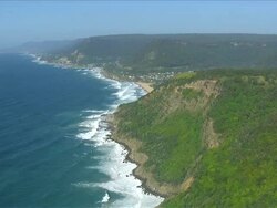 WS AERIAL ZI View of coastline with paragliding over tree covered mountain / Stanwell Park, Sydney New South Wales, Australia Stock Footage