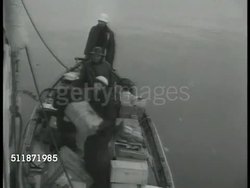 1937: TERRITORY OF ALASKA: US COAST GUARD: MAIL: Male in uniform standing w/ mail bags on cutter deck. Package being thrown down to skiff. MEDICAL: Patient being bandaged in sick bay, eye chart, indigenous native Alaskan woman patient sitting on chair Instructional Video