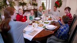 Family toast happily and clink glasses before Christmas dinner (dolly-shot) Stock Footage