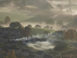 Early morning autumn mist and chimney smoke from the village of Uley, Gloucestershire, UK Stock Footage