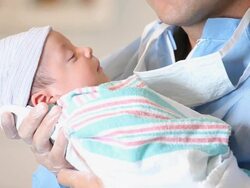 CU TU Newborn Baby Being Held by Father in Surgical Scrubs / Richmond, Virginia, USA Stock Footage