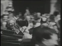Charles Lindbergh and US Ambassador Myron Herrick wave from a balcony overlooking a crowded Paris street. News Clip