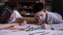 Girl and boy drawing and playing on livingroom floor Stock Footage