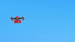 SLO MO UAV transporting first aid kit across blue sky Stock Footage