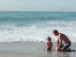MS PAN Man helps boy dig hole on beach while water from ocean fills  hole / Montezuma, Puntarenas, Costa Rica Stock Footage