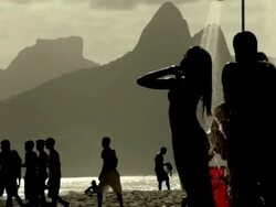 Backlit women under shower at Ipanema beach Stock Footage