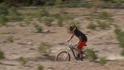 Teenage boy mountain biker doing tricks off dirt jumps. - Slow Motion Stock Footage
