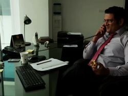 Businessman having a burger and talking on a landline phone   Stock Footage