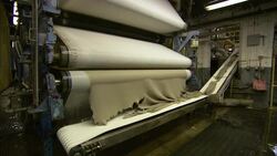 A factory worker tests a piece of pressed cotton during the paper-making process. Stock Footage