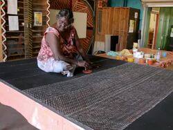 MS Static woman sitting on large canvas creating abstract tiwi art / Northern Territory, Australia Stock Footage