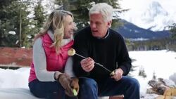Couple toasting marshmallows at fire pit snowy patio Stock Footage