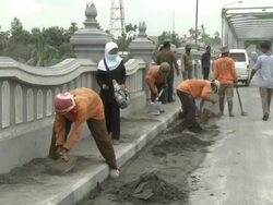 Workers dig to clear volcanic ash off a road bridge west of Yogjakarta during eruption of Merapi volcano; Indonesia. 7 November 2010 / AUDIO Stock Footage