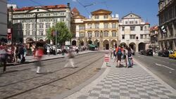 Tourists wait and board red trams from a median in Prague. Stock Footage