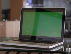 Panning shot of laptop with green screen on table. Stock Footage