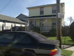 Long Shot tracking-left - Damaged houses line a street in a neighborhood in New Orleans. / New Orleans, Louisiana, USA Stock Footage