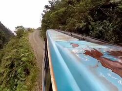 A Bolivian bus jolts along a treacherous mountain dirt track as fog fills the valley below. Stock Footage