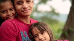 Hispanic teenage brother and younger siblings smile at camera Stock Footage