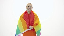 Mature adult holding gay pride flag against white backdrop Stock Footage