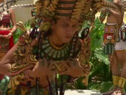 Medium Close Up pan-left pan-right-A man in a feathered headdress and Mayan costume bows and walks around bystanders. / Guatemala Stock Footage