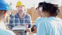Construction foreman explains project to group of volunteers building home for charity Stock Footage