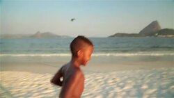 Two Brazilian kids race each other back and forth on Botafogo Beach Stock Footage