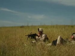 WS One soldier sleeping  down in tall grass while another soldier takes a drink from camelback AUDIO  / Camp Pendleton, CA, United States Stock Footage
