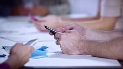 Scrolling on mobile phones at a meeting Stock Footage