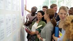Group of smiling students looking at whiteboard Stock Footage