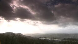 Storm clouds gather over wooded mountains. Stock Footage
