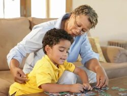 Grandmother and grandson putting together puzzle Stock Footage