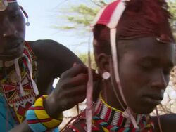 Maasai Ceremony - Young man plaiting young warrior's hair, WITH AUDIO Stock Footage