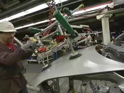 MS PAN Man installing hood on minivan in an auto assembly plant / Princeton, Indiana, United States Stock Footage